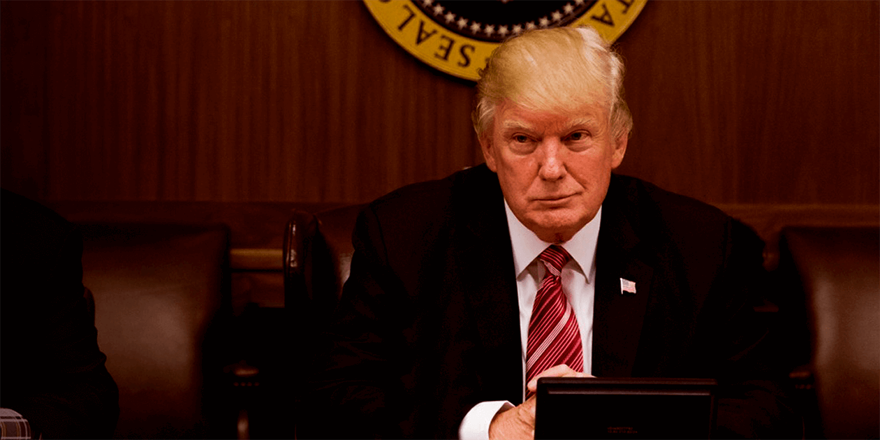 Donald Trump sitting behind a desk.