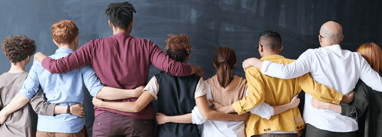 Photo: a diverse group of people, arm in arm, with their backs turned to the camera