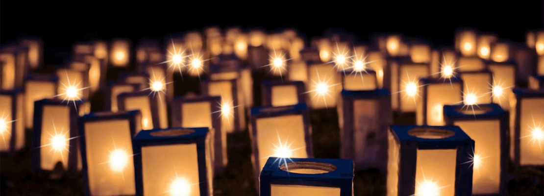 Warmly glowing candles arranged on the ground at night