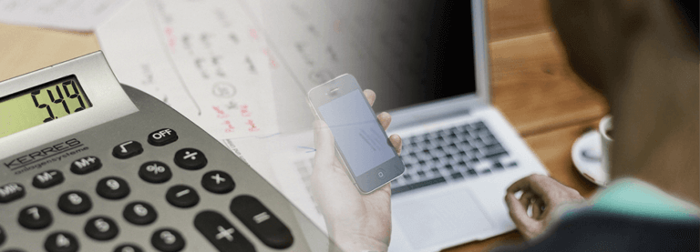Image of a calculator and bills superimposed over an image of a person holding a phone at a computer